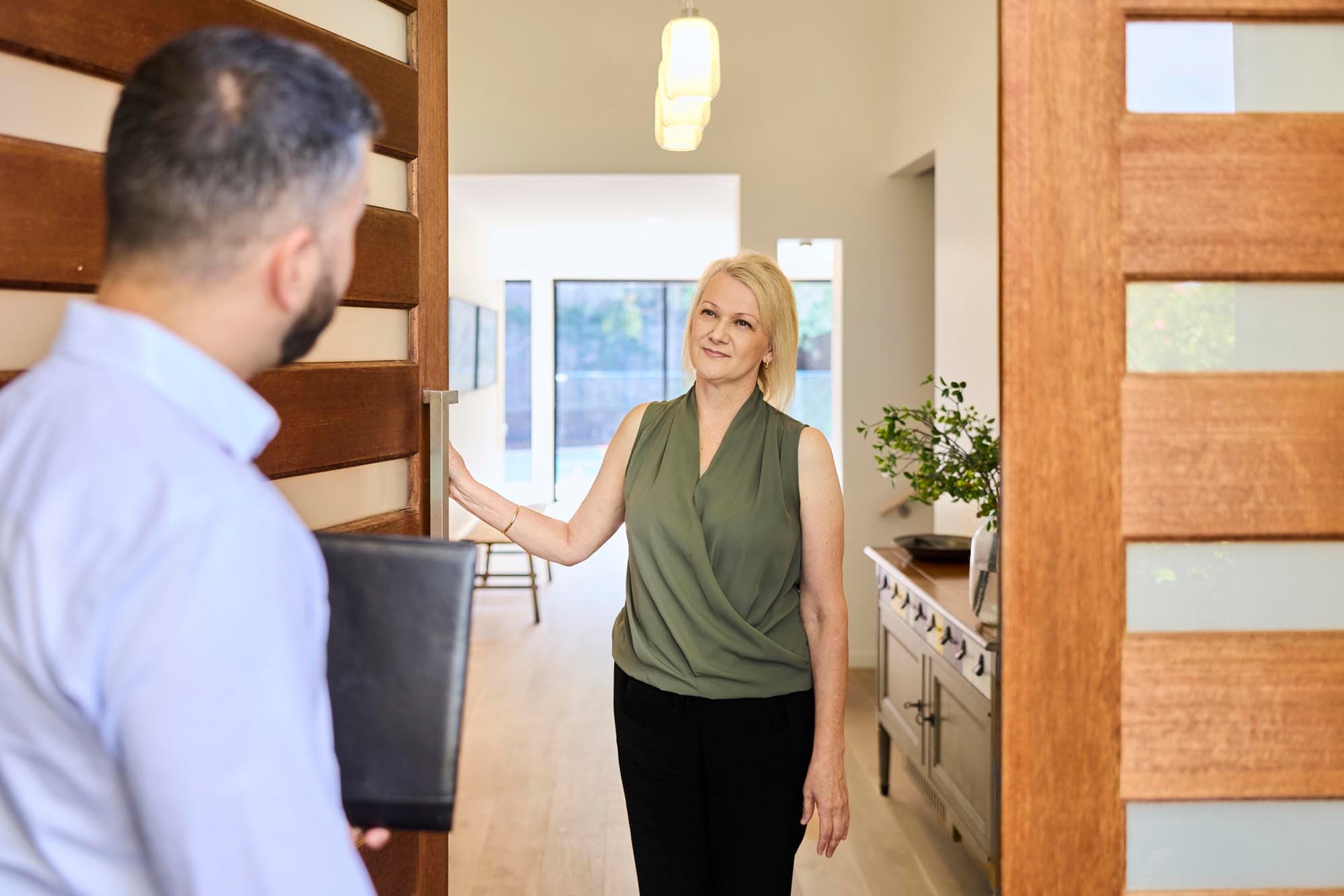 Team member arriving at a client's front door with a clipboard