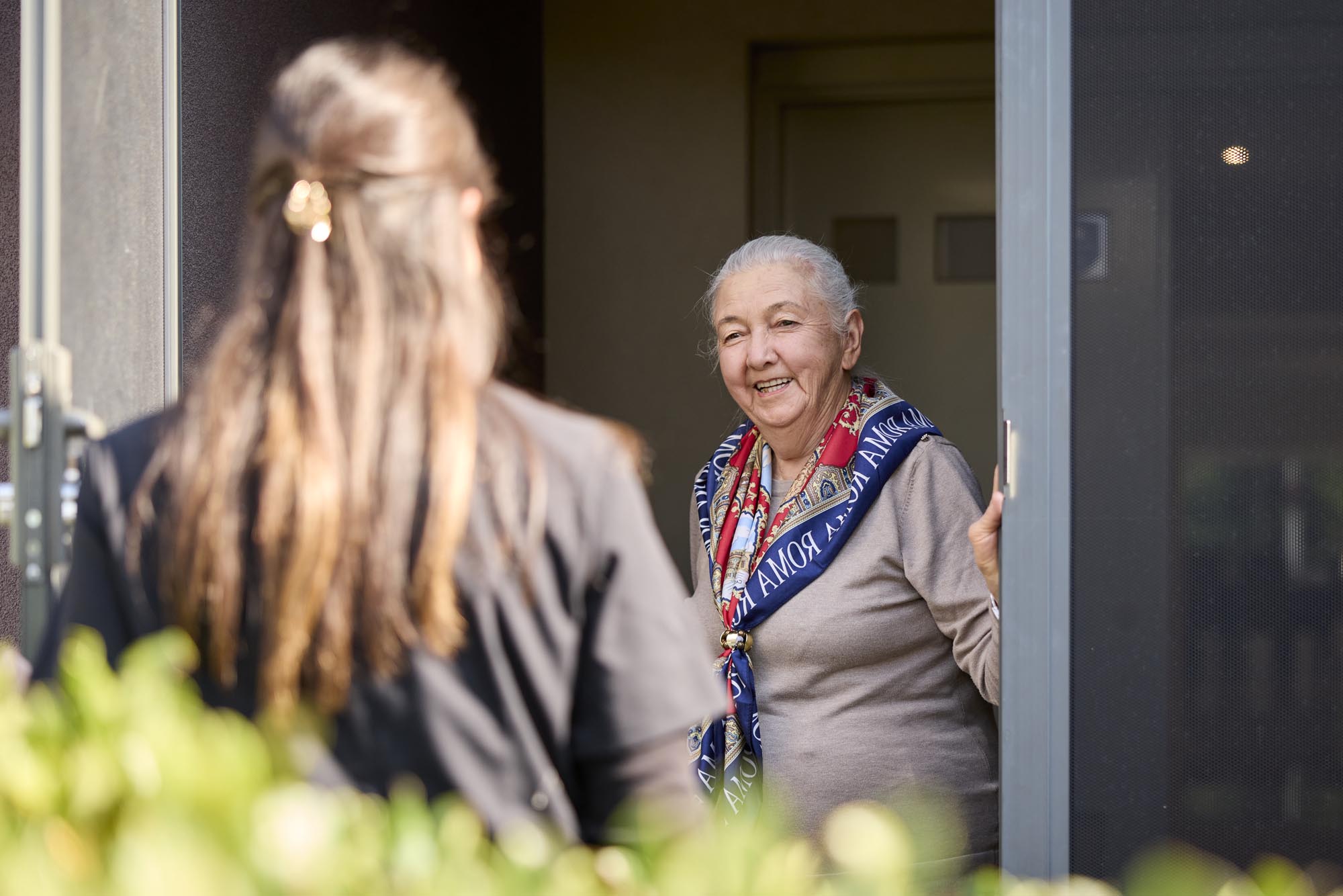 Older client greeting ELM cleaner at the front door